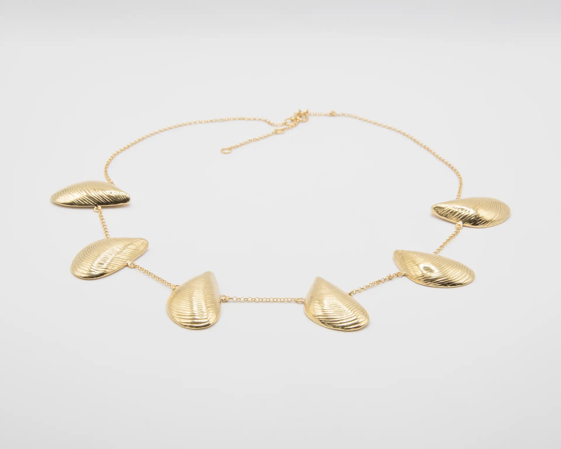 Gargantilla dorada con seis charms en forma de mejillón distribuidos en cadena fina, acabado oro 18k, joyería artesanal Pipa Pirita colección Del Mar