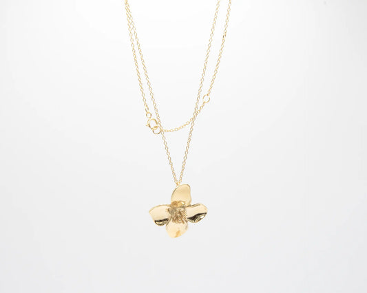 Colgante minimalista con flor de cuatro pétalos en acabado dorado sobre plata de ley 925, cadena fina, joyería artesanal Pipa Pirita colección De la Tierra