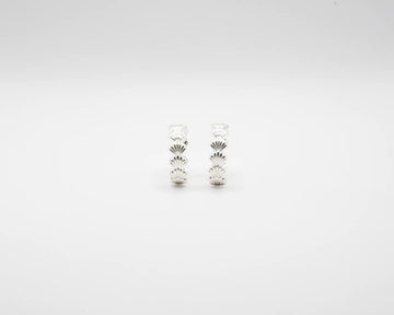 Pendientes de aro en plata de ley con detalle de conchas marinas esculpidas, cierre de presión y acabado artesanal de la marca de joyas Pipa Pirita.