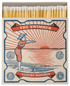 Caja de cerillas cuadrada con ilustración vintage de una mujer con bañador de rayas rojas y blancas saltando al mar, con cerillas largas de madera y punta blanca.