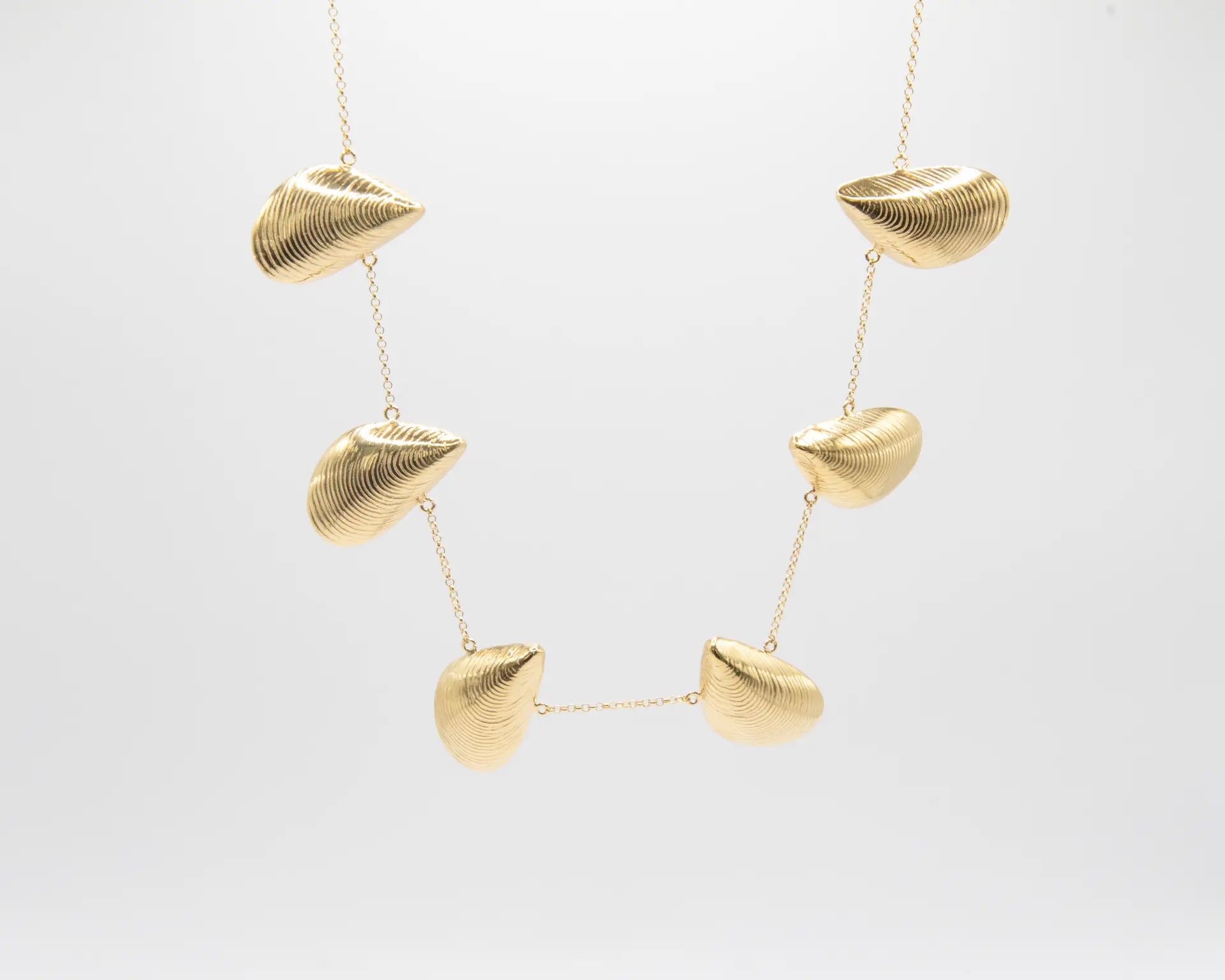 Gargantilla dorada con seis charms en forma de mejillón distribuidos en cadena fina, acabado oro 18k, joyería artesanal Pipa Pirita colección Del Mar