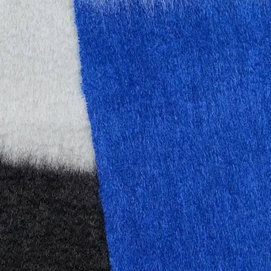 Bufanda de mohair con diseño de bloques de color en tonos contrastados, textura voluminosa de pelo suave y flecos largos hechos a mano en los extremos.