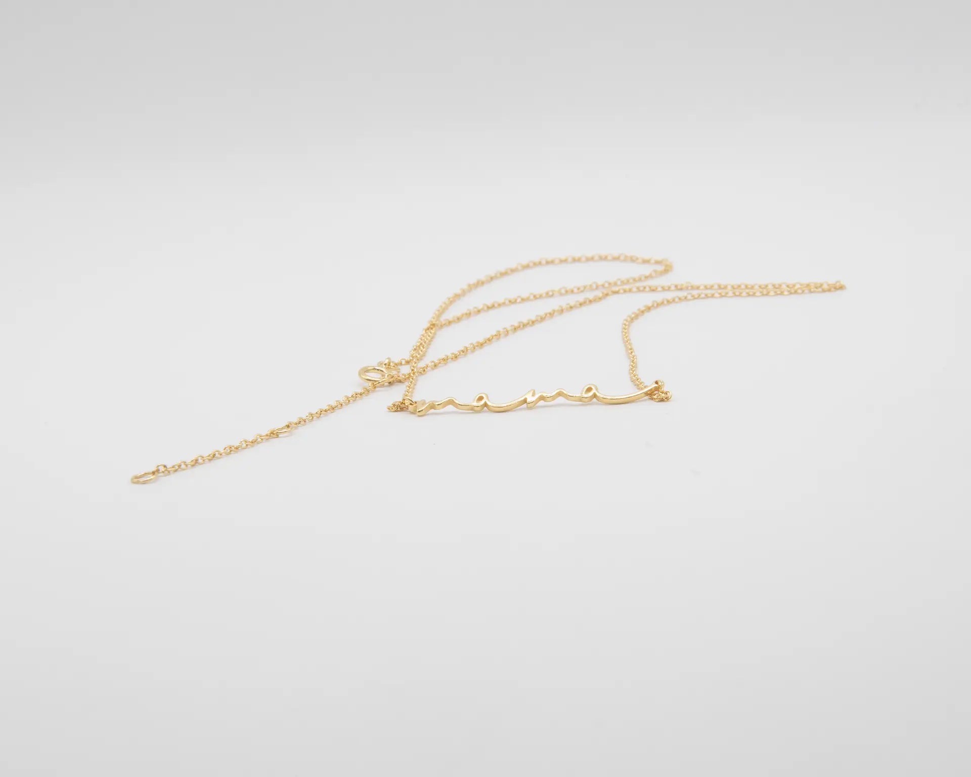 Collar con colgante de la palabra MAMÁ en acabado dorado sobre plata de ley 925, cadena fina con mosquetón, joyería artesanal Pipa Pirita colección Vínculos