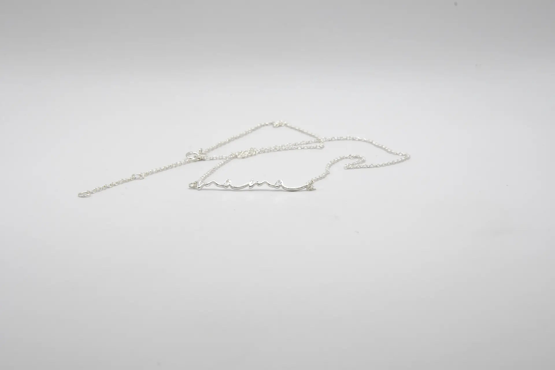 

Collar con colgante de la palabra MAMÁ en plata de ley 925, cadena fina con mosquetón, joyería artesanal Pipa Pirita colección Vínculos