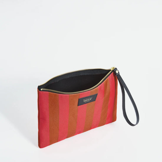 Bolso de mano tipo sobre de gran tamaño con estampado de rayas en tonos naranja y rosa, con cierre de cremallera superior y etiqueta de cuero