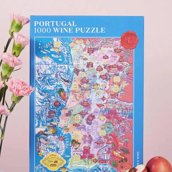 Puzzle de 1000 piezas que representa un mapa ilustrado de Portugal con sus regiones vinícolas, variedades de uva y elementos culturales sobre un fondo azul oscuro.