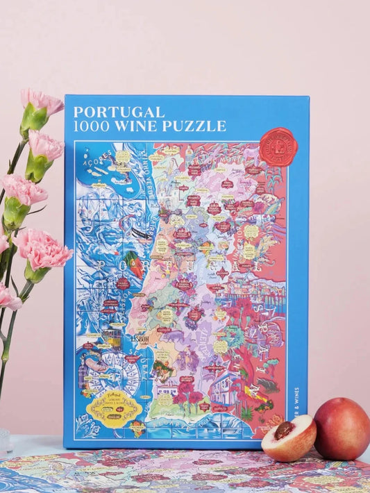 Puzzle de 1000 piezas que representa un mapa ilustrado de Portugal con sus regiones vinícolas, variedades de uva y elementos culturales sobre un fondo azul oscuro.