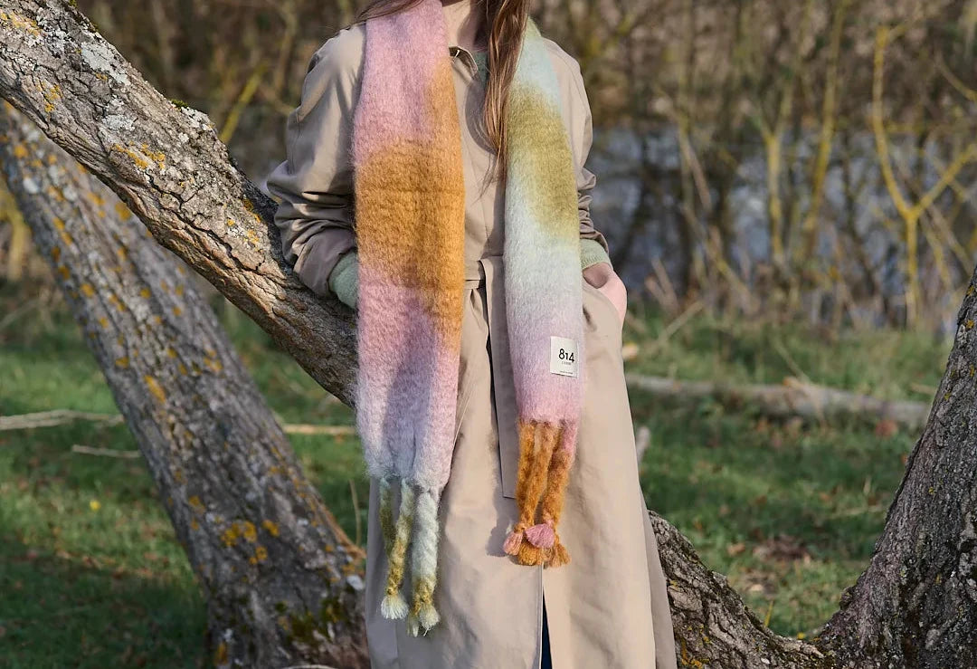 Bufanda de mohair voluminosa con diseño artesanal tie-dye en tonos cálidos y naturales, con flecos largos manuales y textura de pelo suave.