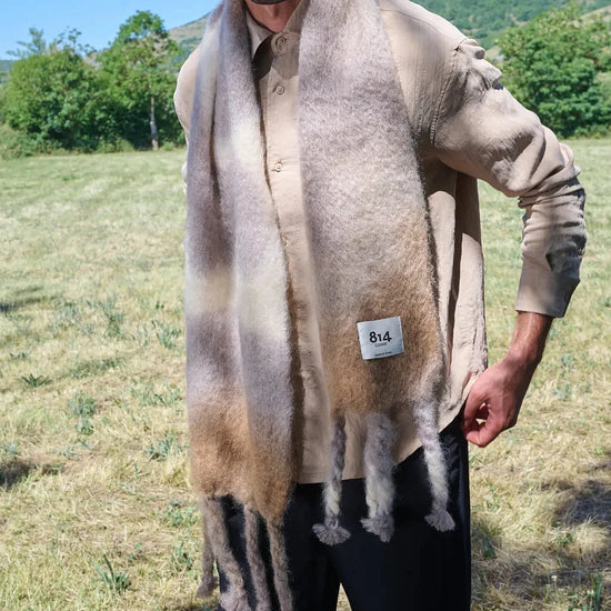 Bufanda de mohair y lana con estampado artesanal tie-dye en tonos degradados azules y naturales, con flecos largos hechos a mano en los extremos.