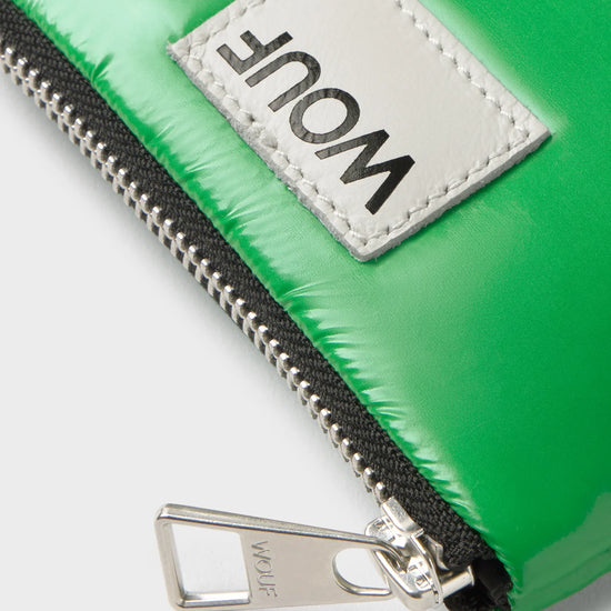 Cartera pequeña de color verde oscuro con acabado brillante, cierre de cremallera superior, ranura trasera de cuero para tarjetas y etiqueta frontal de Wouf