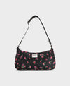Bolso de hombro con estampado floral colorido sobre fondo oscuro, silueta suave y relajada, con correa ajustable negra y etiqueta de cuero reciclado de Wouf.