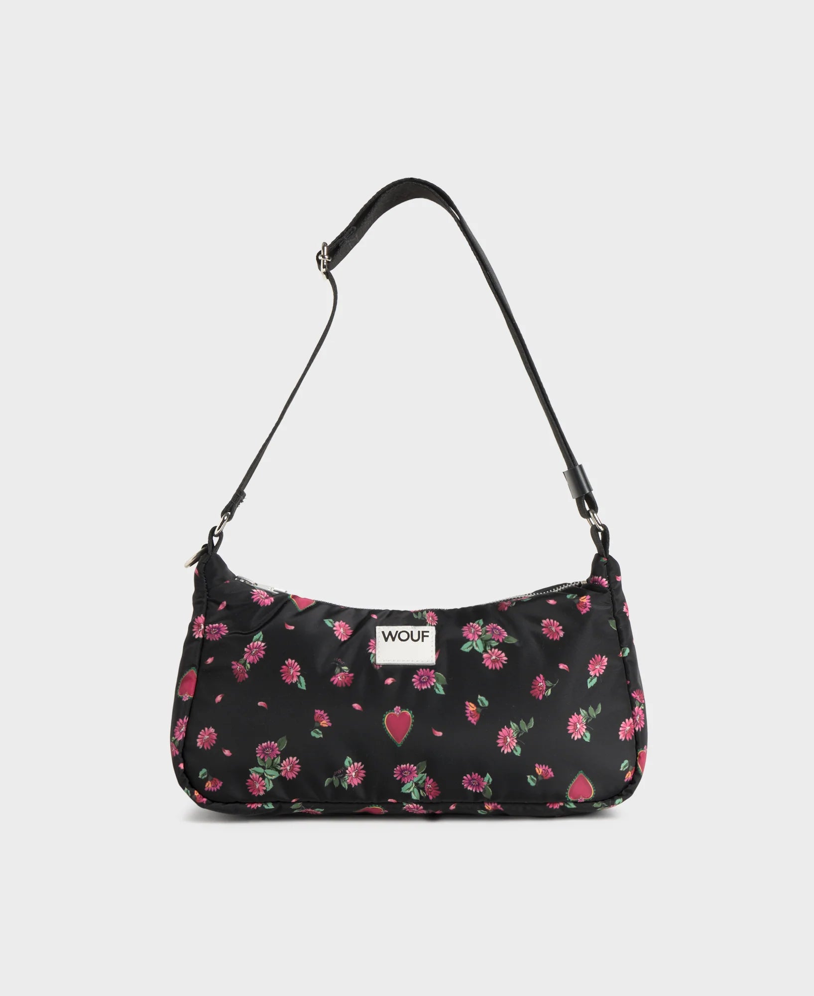 Bolso de hombro con estampado floral colorido sobre fondo oscuro, silueta suave y relajada, con correa ajustable negra y etiqueta de cuero reciclado de Wouf.