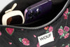 Bolso de hombro con estampado floral colorido sobre fondo oscuro, silueta suave y relajada, con correa ajustable negra y etiqueta de cuero reciclado de Wouf.