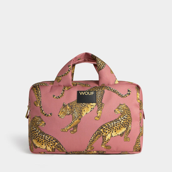 Neceser de gran tamaño con estampado de leopardo en tonos negros y marrones sobre fondo rosa claro, con cierre de cremallera superior y etiqueta de cuero de Wouf.
