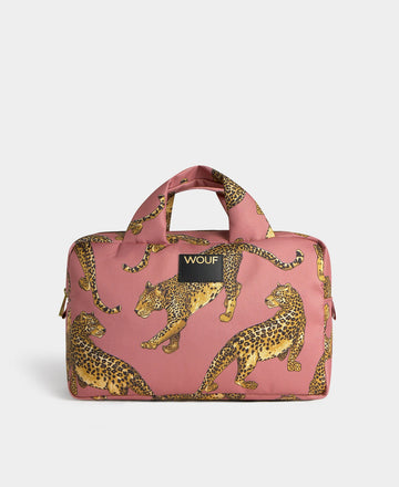 Neceser de gran tamaño con estampado de leopardo en tonos negros y marrones sobre fondo rosa claro, con cierre de cremallera superior y etiqueta de cuero de Wouf.

