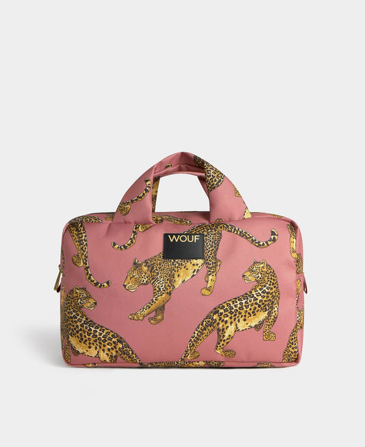 Neceser de gran tamaño con estampado de leopardo en tonos negros y marrones sobre fondo rosa claro, con cierre de cremallera superior y etiqueta de cuero de Wouf.
