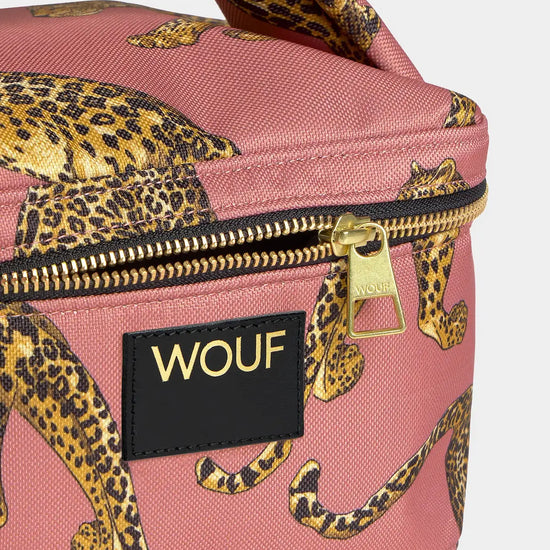 Neceser de gran tamaño con estampado de leopardo en tonos negros y marrones sobre fondo rosa claro, con cierre de cremallera superior y etiqueta de cuero de Wouf.
