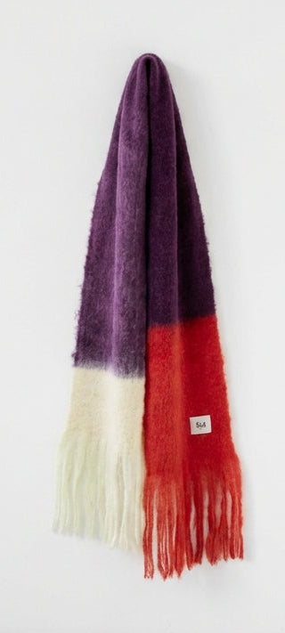 Bufanda de mohair voluminosa con diseño bicolor en morado y rojo, terminada en flecos y con textura de pelo suave, fabricada artesanalmente en Ezcaray.