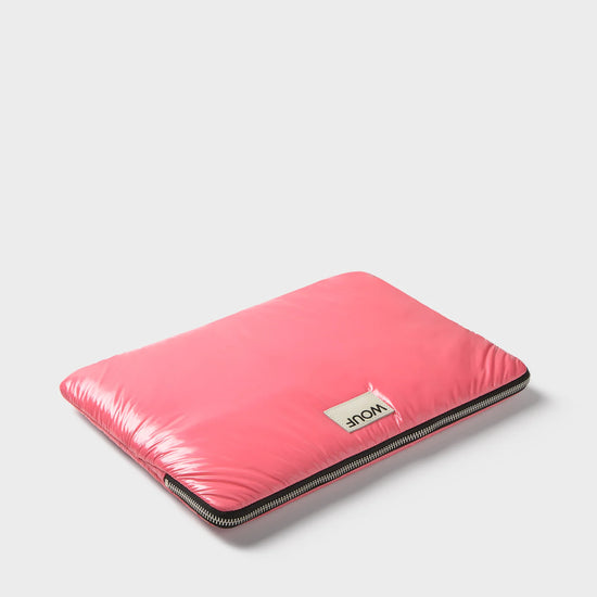 Funda protectora acolchada para portátil de 13 y 14 pulgadas con acabado brillante en color rosa dulce, cierre de cremallera superior y etiqueta de cuero con logo.