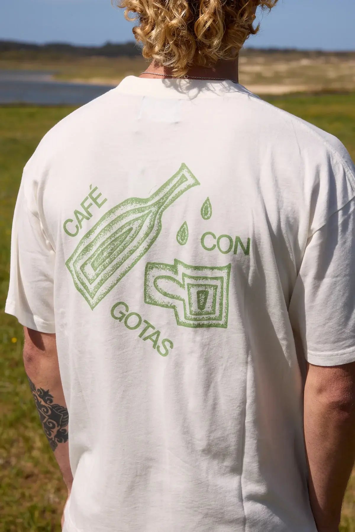 Camiseta de manga corta y corte holgado con diseño gráfico original "Café con Gotas", confeccionada de forma ética en algodón orgánico por la marca NWHR.