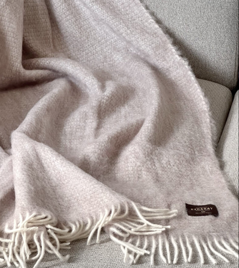 Manta de sofá de mohair en color beige crema con textura voluminosa de pelo suave, terminada con flecos y fabricada de forma artesanal en Ezcaray.