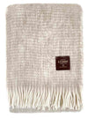 Manta de sofá de mohair en color beige crema con textura voluminosa de pelo suave, terminada con flecos y fabricada de forma artesanal en Ezcaray.