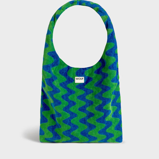 Bolso grande tipo camiseta en tejido de rizo de algodón orgánico color crudo, de tacto toalla con asas integradas y etiqueta de silicona, marca Wouf.