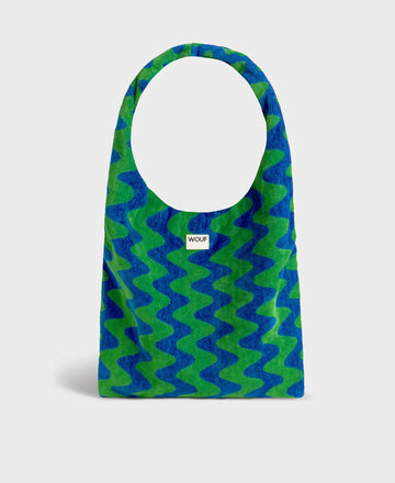 Bolso grande tipo camiseta en tejido de rizo de algodón orgánico color crudo, de tacto toalla con asas integradas y etiqueta de silicona, marca Wouf.