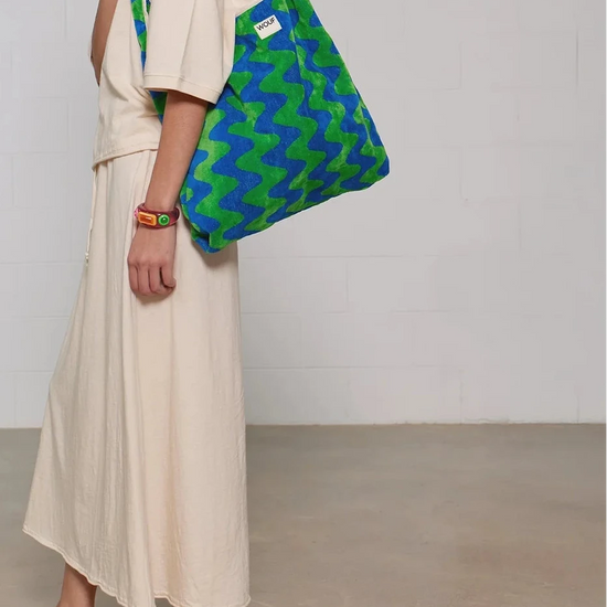 Bolso grande tipo camiseta en tejido de rizo de algodón orgánico color crudo, de tacto toalla con asas integradas y etiqueta de silicona, marca Wouf.