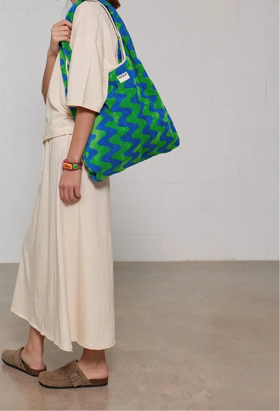 Bolso grande tipo camiseta en tejido de rizo de algodón orgánico color crudo, de tacto toalla con asas integradas y etiqueta de silicona, marca Wouf.