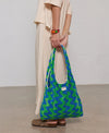 Bolso grande tipo camiseta en tejido de rizo de algodón orgánico color crudo, de tacto toalla con asas integradas y etiqueta de silicona, marca Wouf.
