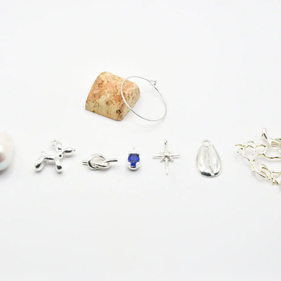 Set de siete identificadores de copa en latón chapado en plata, presentados en bote de vidrio con tapón de corcho, colección Brindis de Alquimia de Pipa Pirita