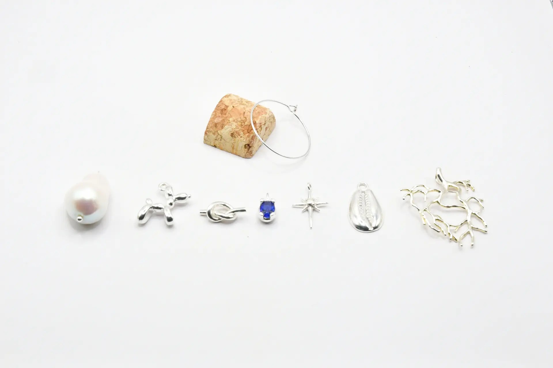 Set de siete identificadores de copa en latón chapado en plata, presentados en bote de vidrio con tapón de corcho, colección Brindis de Alquimia de Pipa Pirita
