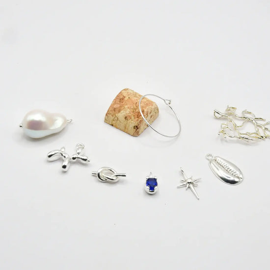 Set de siete identificadores de copa en latón chapado en plata, presentados en bote de vidrio con tapón de corcho, colección Brindis de Alquimia de Pipa Pirita