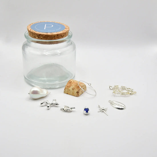 Set de siete identificadores de copa en latón chapado en plata, presentados en bote de vidrio con tapón de corcho, colección Brindis de Alquimia de Pipa Pirita