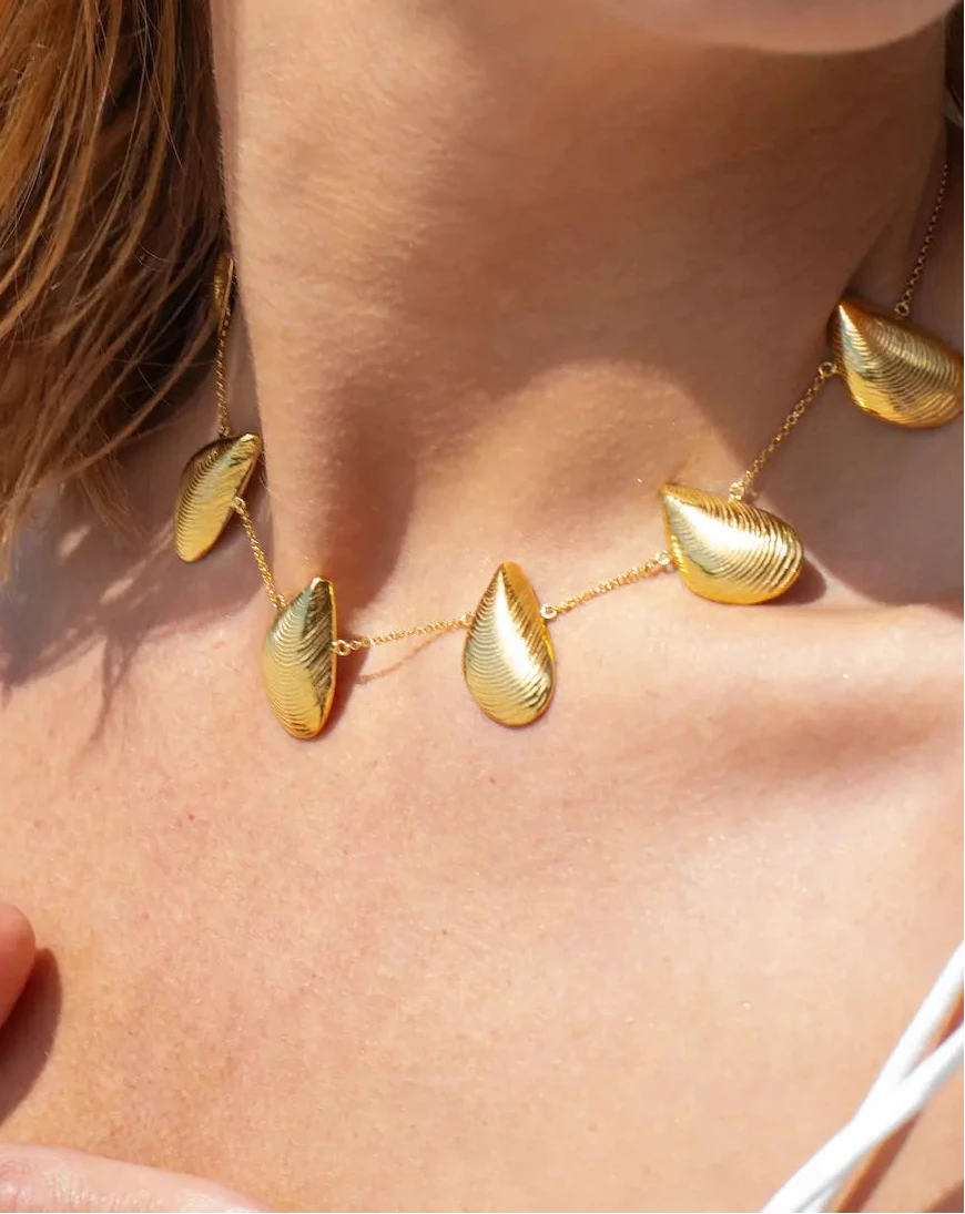 Gargantilla dorada con seis charms en forma de mejillón distribuidos en cadena fina, acabado oro 18k, joyería artesanal Pipa Pirita colección Del Mar