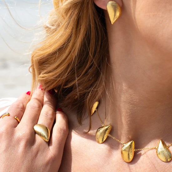 Pendientes pequeños de plata con forma de mejillón chapados en oro de 18k, con cierre de presión y diseño artesanal de la marca Pipa Pirita.