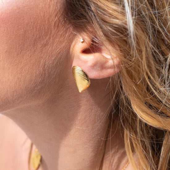 Pendientes pequeños de plata con forma de mejillón chapados en oro de 18k, con cierre de presión y diseño artesanal de la marca Pipa Pirita.