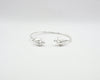

Pulsera torque abierta con caracolas en los extremos, acabado plata, colección Del Mar de Pipa Pirita, joyería artesanal de inspiración atlántica