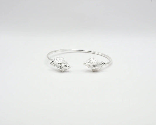 

Pulsera torque abierta con caracolas en los extremos, acabado plata, colección Del Mar de Pipa Pirita, joyería artesanal de inspiración atlántica
