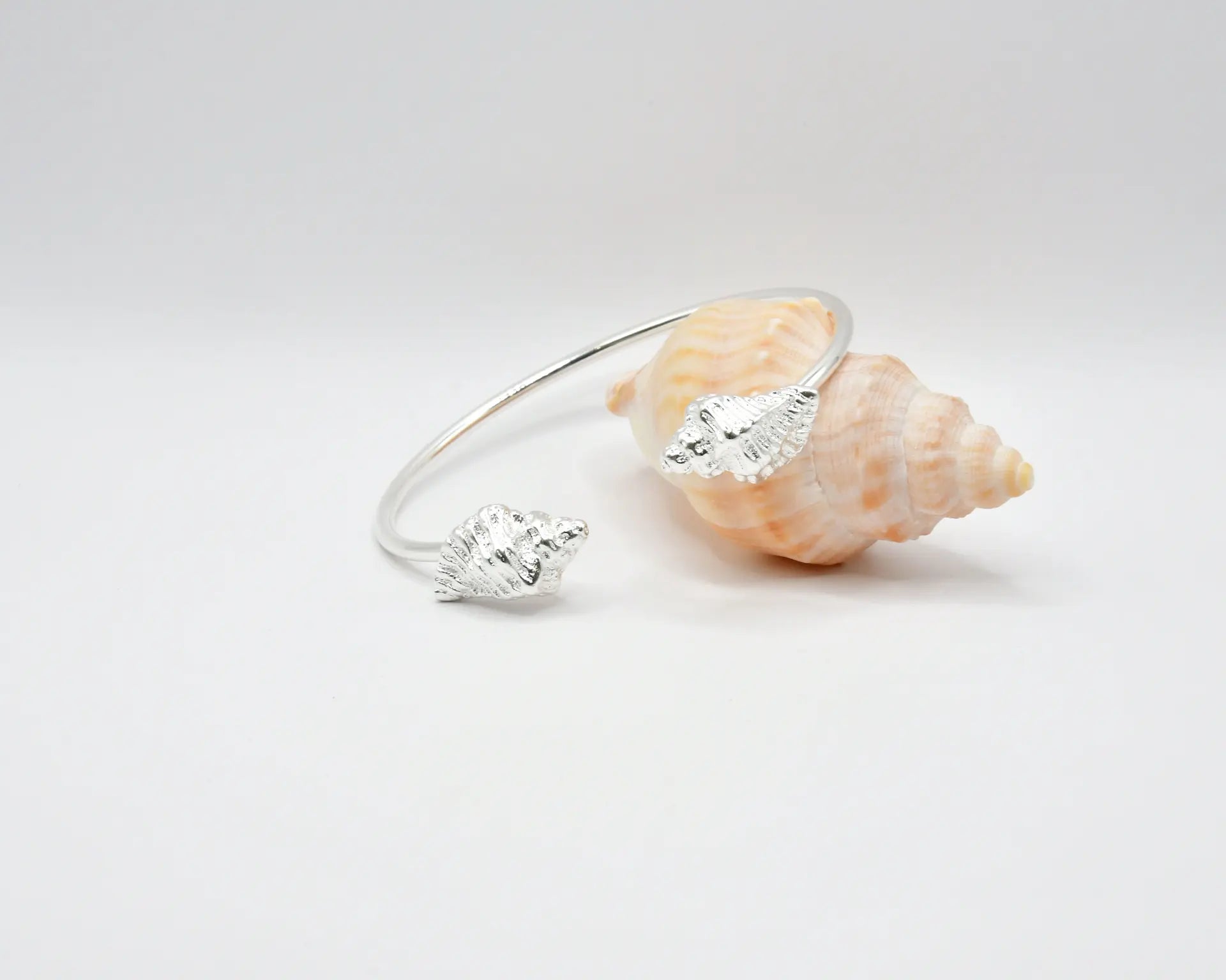 

Pulsera torque abierta con caracolas en los extremos, acabado plata, colección Del Mar de Pipa Pirita, joyería artesanal de inspiración atlántica