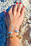 

Pulsera torque abierta con caracolas en los extremos, acabado plata, colección Del Mar de Pipa Pirita, joyería artesanal de inspiración atlántica