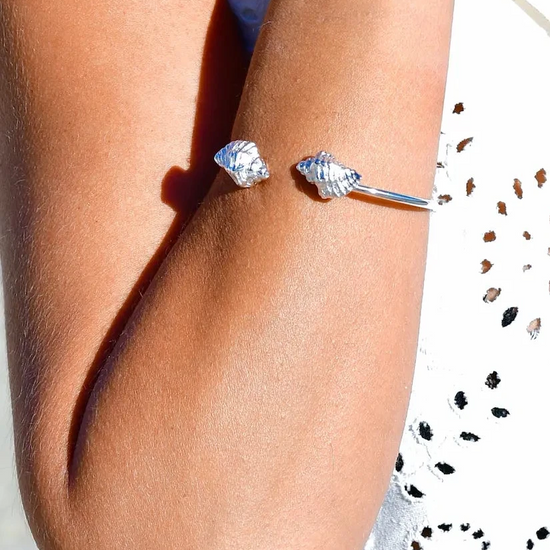 

Pulsera torque abierta con caracolas en los extremos, acabado plata, colección Del Mar de Pipa Pirita, joyería artesanal de inspiración atlántica