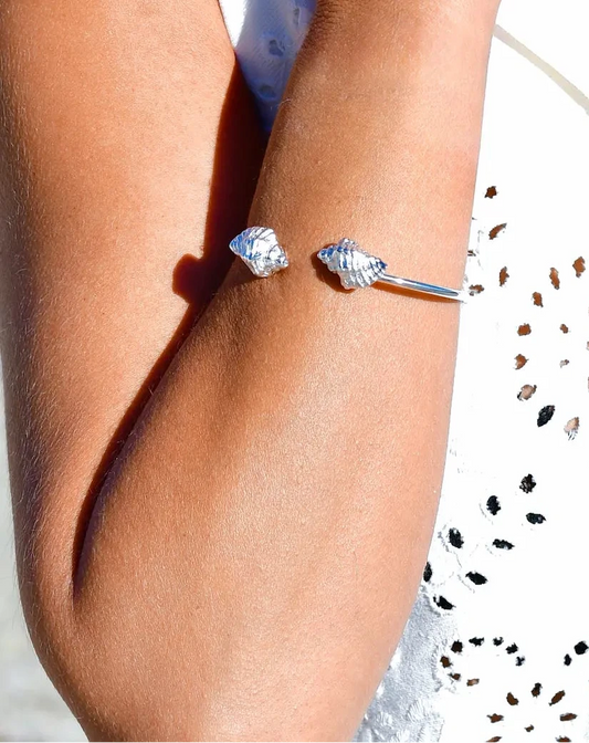 

Pulsera torque abierta con caracolas en los extremos, acabado plata, colección Del Mar de Pipa Pirita, joyería artesanal de inspiración atlántica