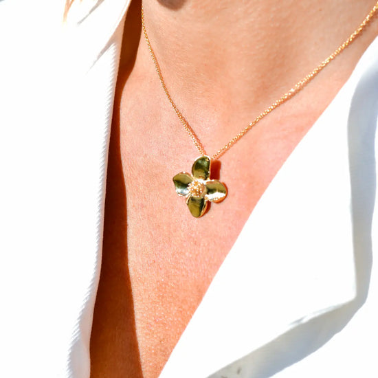 Colgante minimalista con flor de cuatro pétalos en acabado dorado sobre plata de ley 925, cadena fina, joyería artesanal Pipa Pirita colección De la Tierra