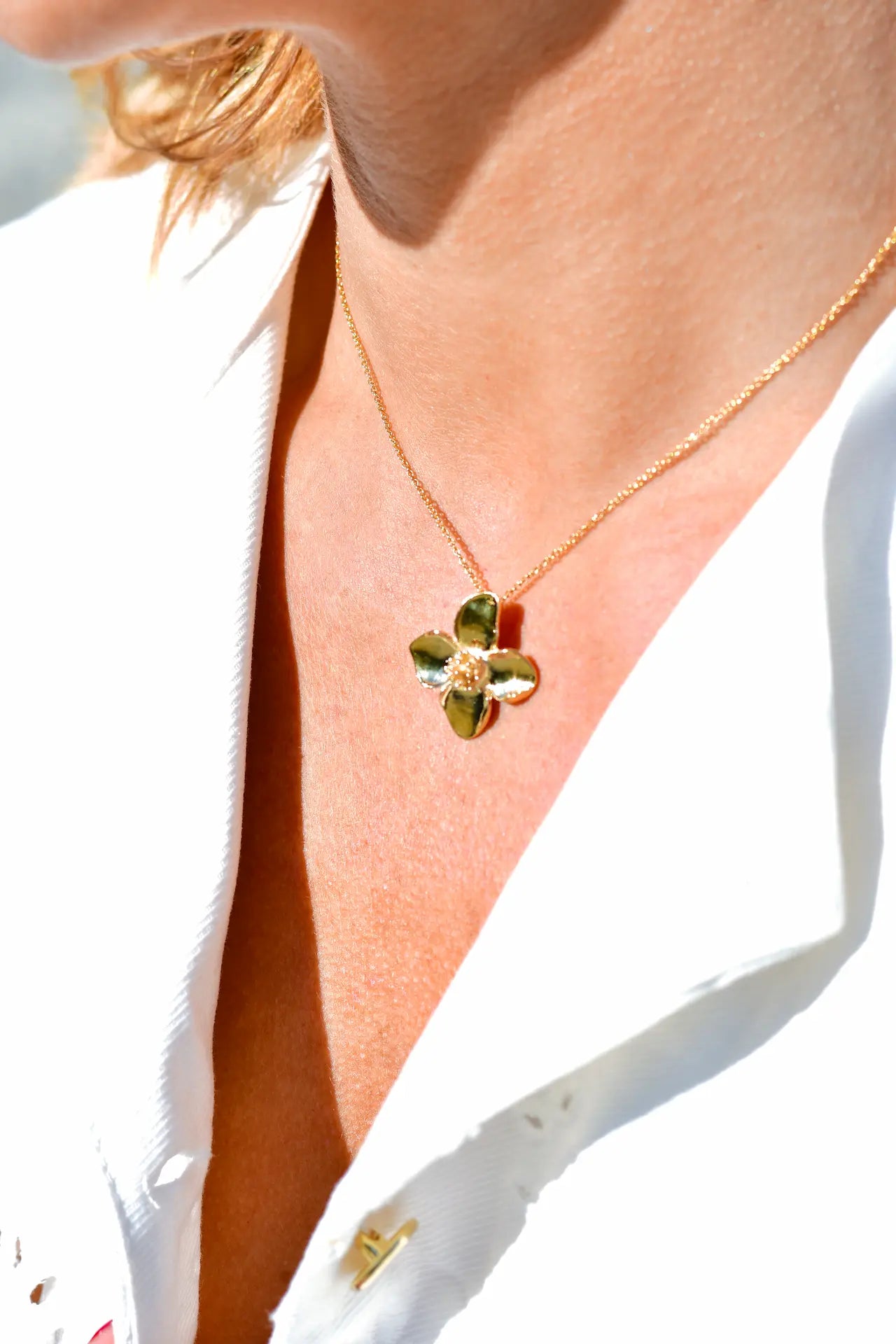 Colgante minimalista con flor de cuatro pétalos en acabado dorado sobre plata de ley 925, cadena fina, joyería artesanal Pipa Pirita colección De la Tierra