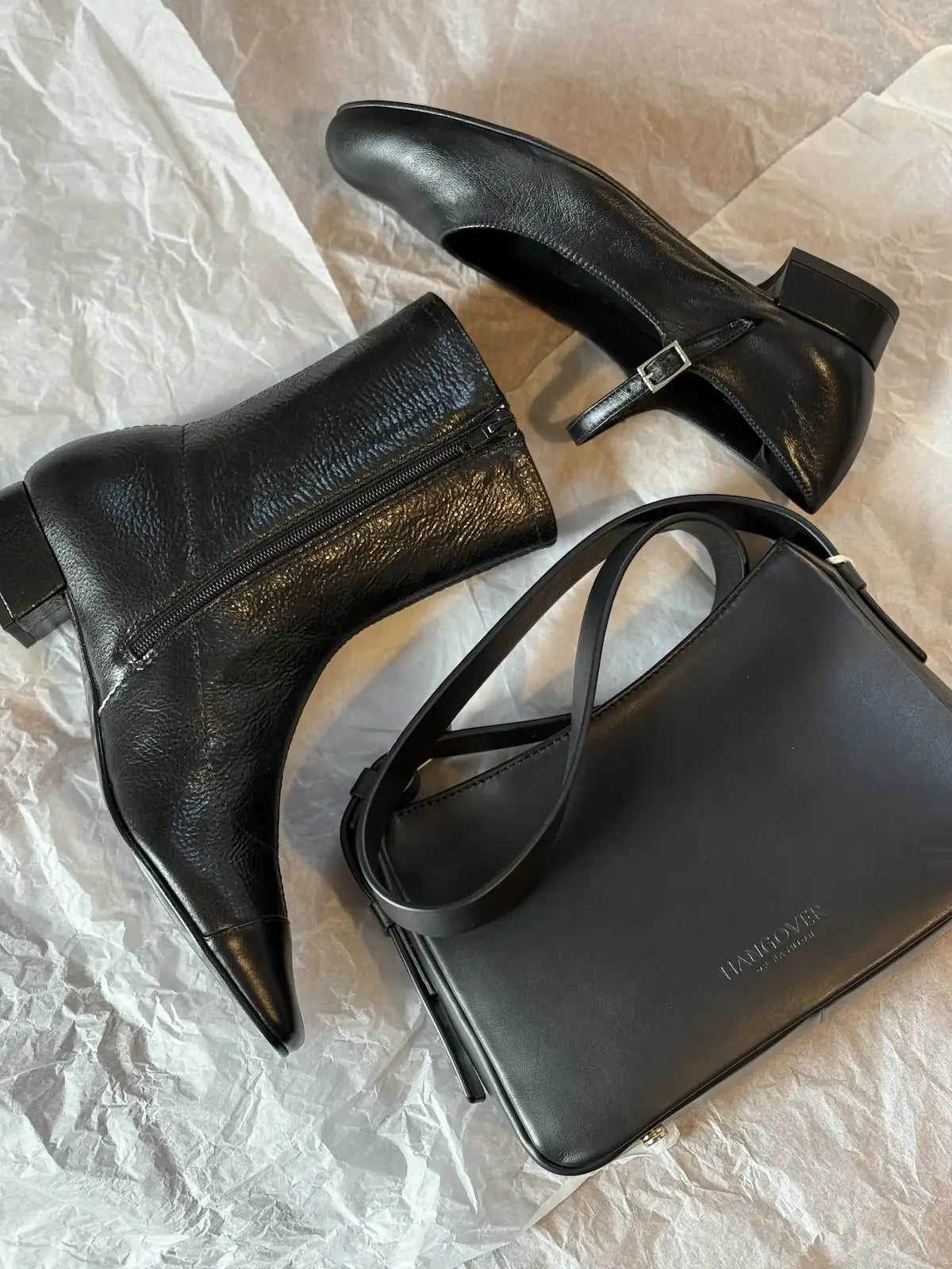 Bolso pequeño estructurado de piel napa negra con asa ajustable y diseño minimalista de la marca Hangover of Fashion, fabricado artesanalmente en España.