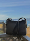 Bolso pequeño estructurado de piel napa negra con asa ajustable y diseño minimalista de la marca Hangover of Fashion, fabricado artesanalmente en España.