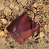 Bolso tipo bombonera de piel lisa color burdeos con asa corta de mano y bandolera ajustable, cierre de imán y fabricación artesanal española de The Code.