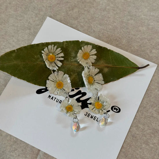 Pendientes Tres Margaritas de Syringa Jewels: Bellis
perennis en resina UV en cascada con colgante de cristal.